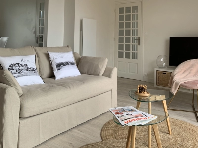 Séjour confortable avec canapé, TV, table basse et fauteuils 