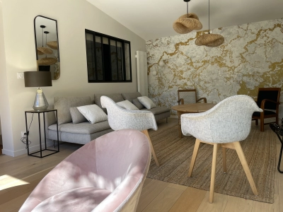 Salon chaleureux et lumineux avec grand canapé et fauteuils 