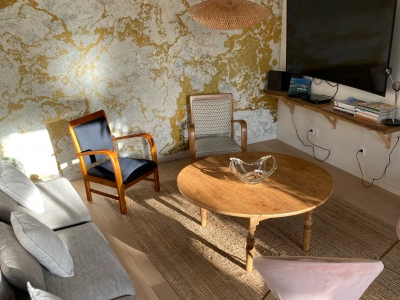 Salon chaleureux et lumineux avec TV, fauteuil et table basse